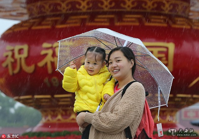 北京遭遇强降雨气温大“跳水” 游客冒雨游览天安门广场