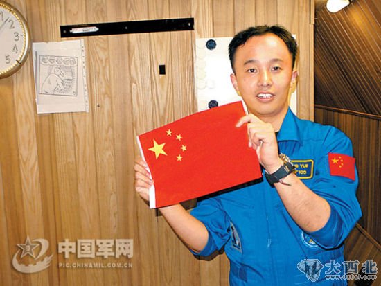 资料图:王跃在试验舱内展示国旗。