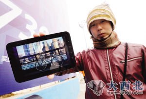 昨天,在楚河汉街,河源启一郎将他的自行车图片展示给路人看。记者陈亮 摄 昨天,在楚河汉街,河源启一郎将他的自行车图片展示给路人看。记者陈亮 摄