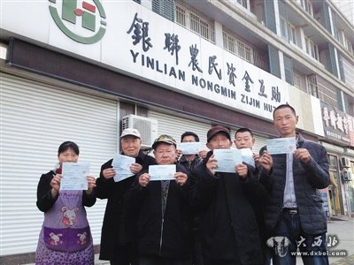 11月15日,江苏盐城市银联农民资金互助合作社门口,多位“储户”手持还未兑现的存款凭条。这家合作社将互助资金投资房产项目失败,导致资金链断裂倒闭。新京报记者 谷岳飞 摄