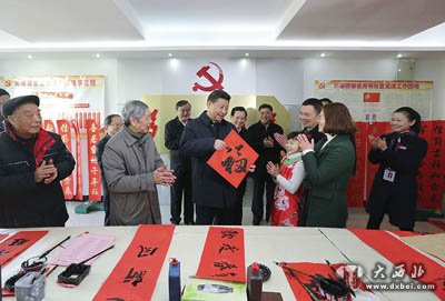 习近平在南昌市东湖区彭家桥街道光明社区书画室,接过一位小朋友现场书写的 “福”字,祝大家都幸福