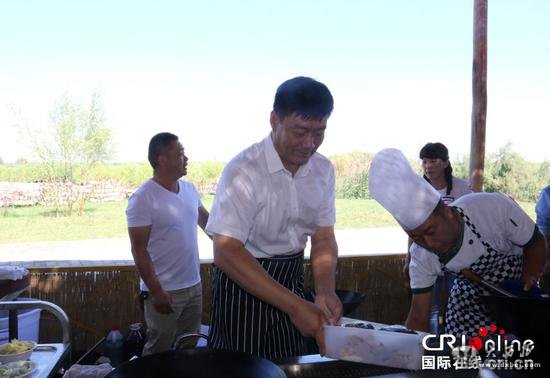 博湖县委书记董斌在进行做鱼前的准备工作。 摄影：杨欢