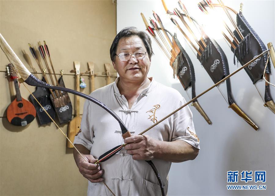 来自新疆伊犁哈萨克自治州察布查尔锡伯自治县的弓箭艺人赵玉书在工作室内展示自己制作的传统弓箭(2018年9月14日摄)。
