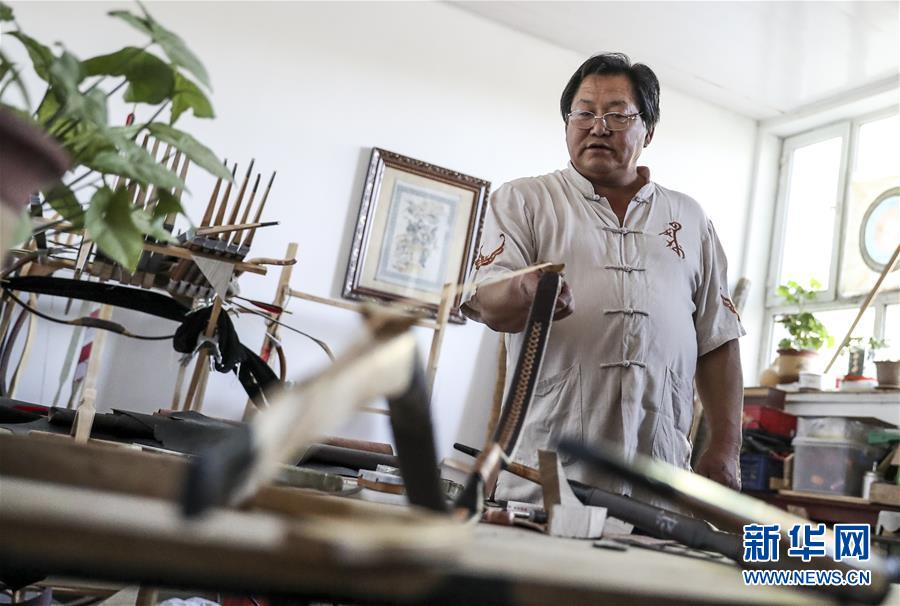 来自新疆伊犁哈萨克自治州察布查尔锡伯自治县的弓箭艺人赵玉书在工作室内制作传统弓箭(2018年9月14日摄)。