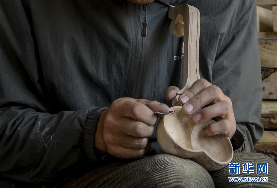 新疆乌鲁木齐县甘沟乡哈萨克族民间木制餐具传承人叶尔布力·白山在制作木碗(2016年9月30日摄)。